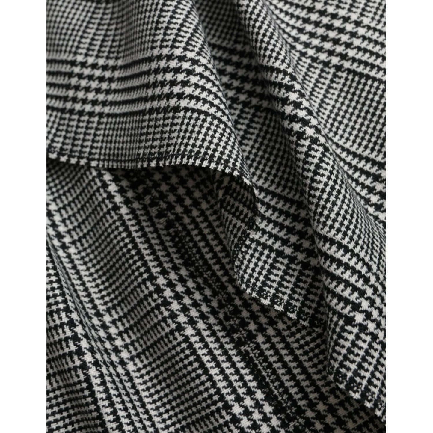 Close-up of Dolce & Gabbana gray beige plaid fabric, showcasing the intricate houndstooth pattern and texture.