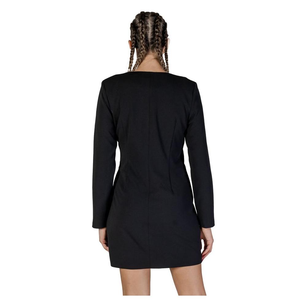 Back view of woman wearing a short black polyester dress, perfect for fall and winter, showcasing long sleeves and sleek design.