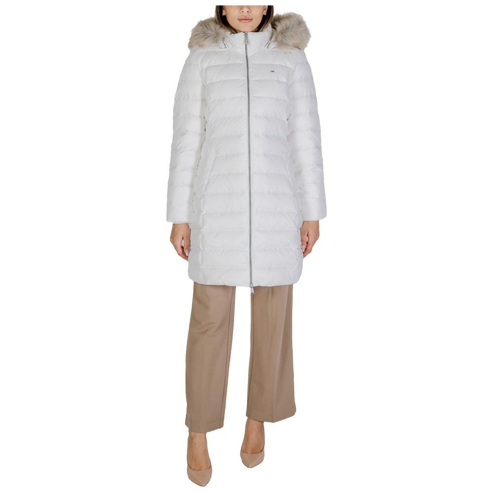 Woman wearing Tommy Hilfiger white recycled polyester coat with faux fur hood, fall/winter collection.