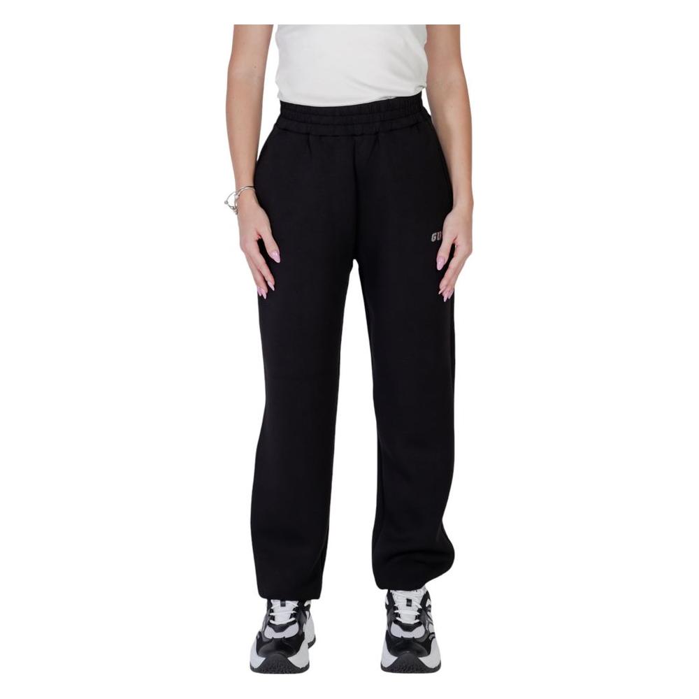 Woman wearing Guess Active Black Viscose Jogger Pants with elastic waistband, side pockets, and casual sneakers.
