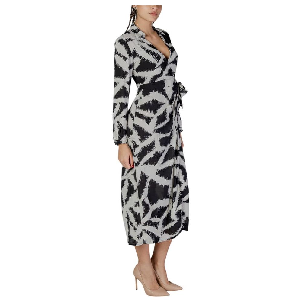 Woman wearing Jacqueline De Yong black recycled polyester dress, fall/winter collection, featuring a long design with abstract pattern.