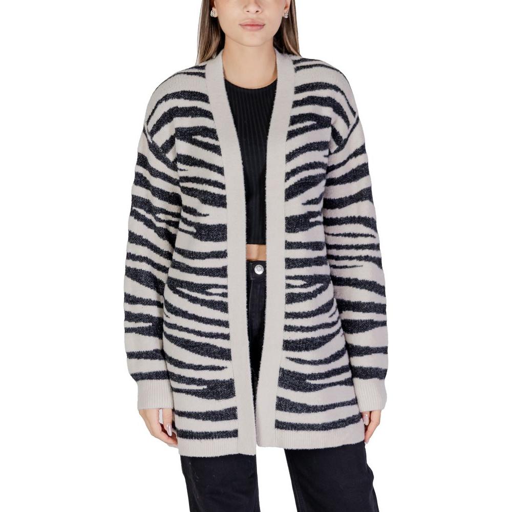 Woman wearing a Jacqueline De Yong zebra print gray nylon cardigan, perfect for fall and winter. Composition: 58% Nylon, 26% Viscose, 16% Polyester.