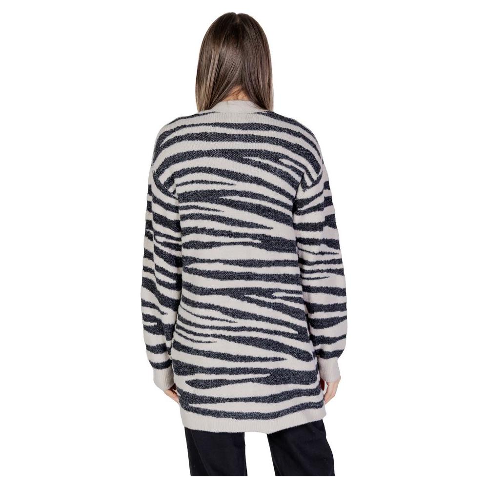 Back view of a woman wearing a Jacqueline De Yong gray nylon zebra striped cardigan, highlighting knitwear with fall/winter style.