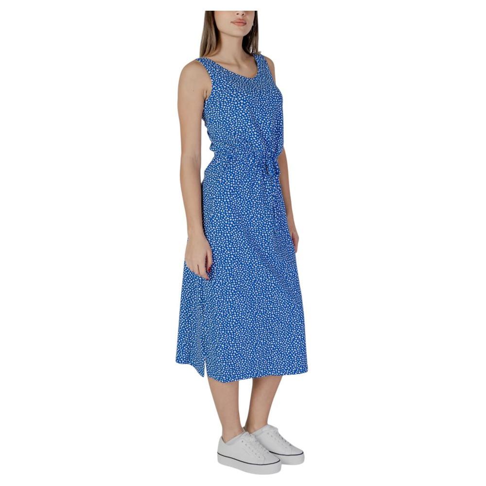 Woman wearing blue sleeveless dress with white sneakers