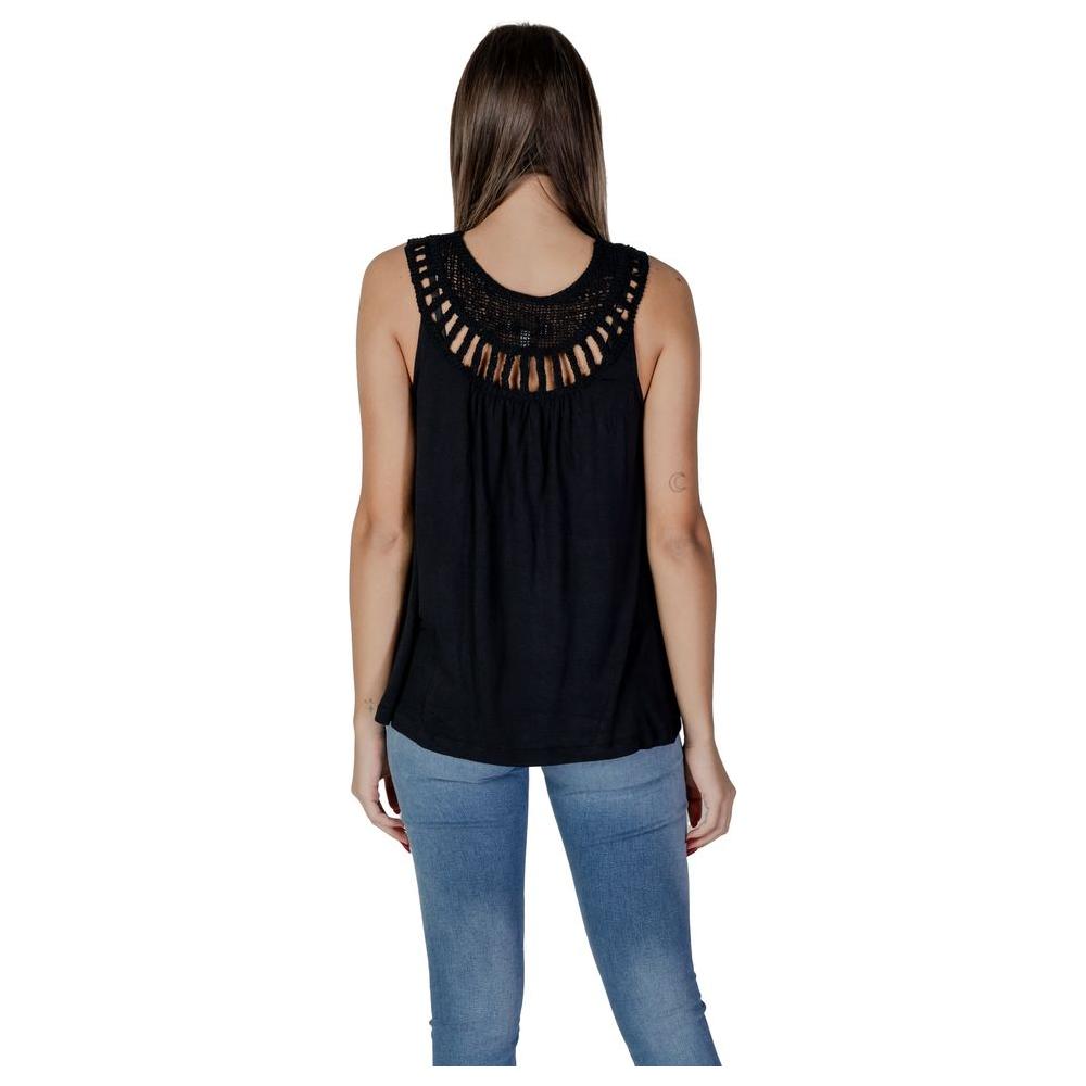 Woman wearing a black viscose top from B.Young's spring/summer collection, featuring a detailed crochet neckline and sleeveless design.