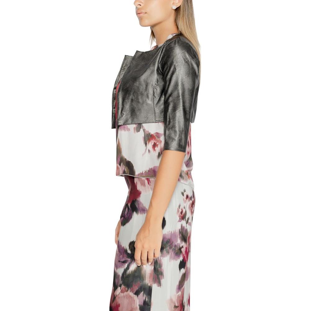Woman wearing Rinascimento gray polyethylene top with floral skirt, shoulder cover style, fall/winter collection, polyurethane fabric.