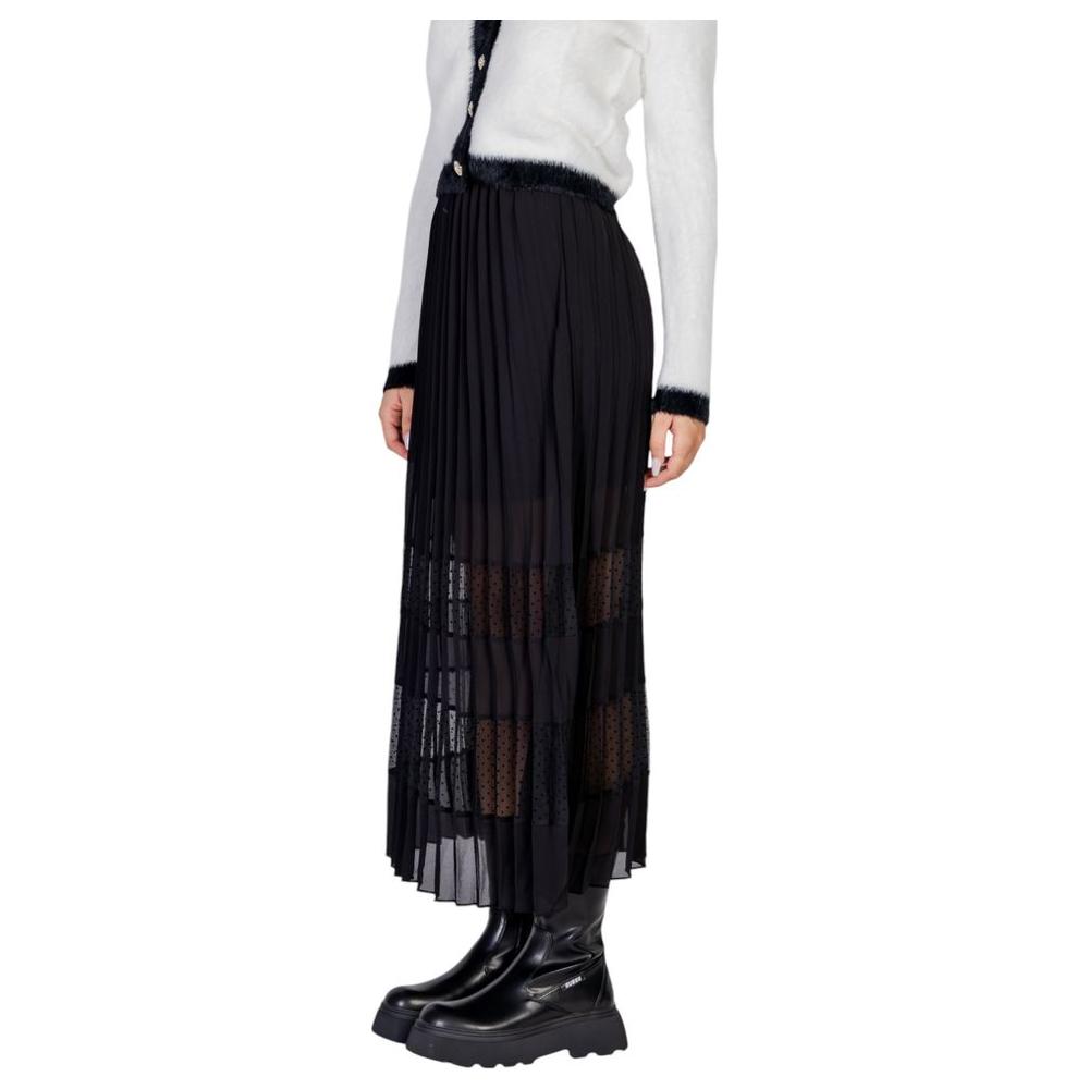 Morgan De Toi women’s black pleated polyester skirt, fall/winter collection, paired with white top and black boots.