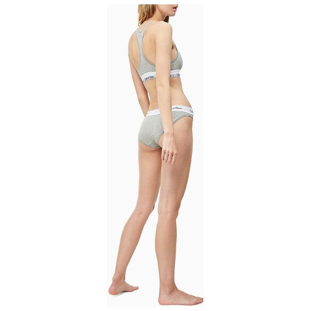 Women's gray Calvin Klein underwear briefs with logo waistband, shown on model, offering comfort and style with cotton blend fabric.