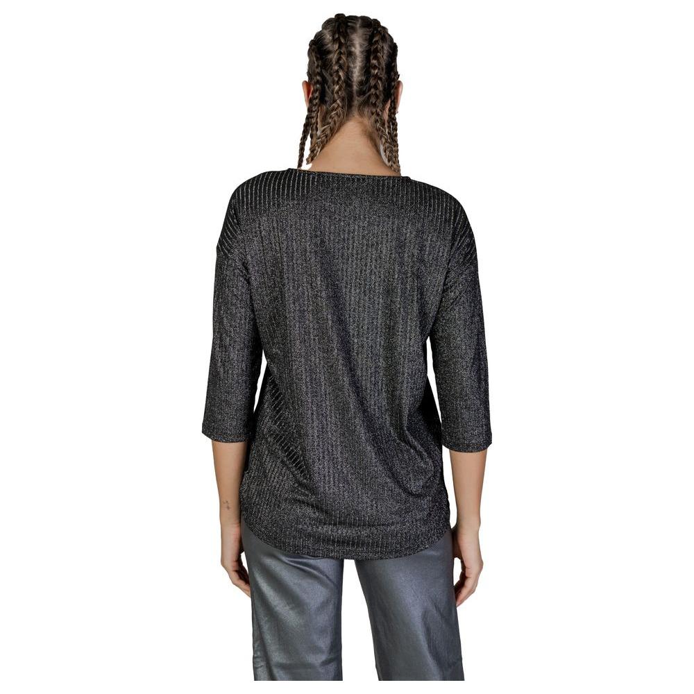 Back view of woman wearing Vero Moda bicolor long-sleeved top, made of recycled polyester and elastane, fall/winter fashion.