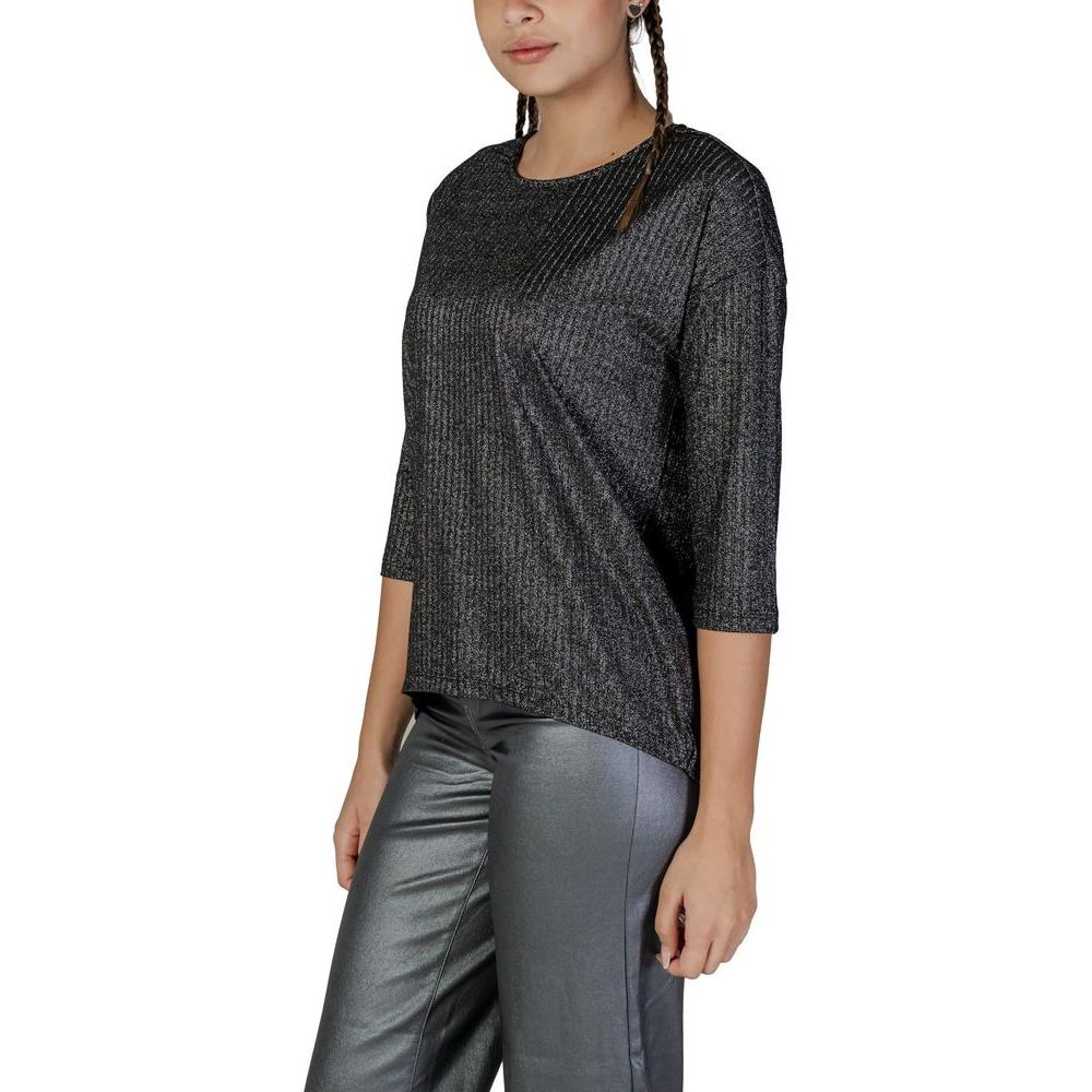 Woman wearing Vero Moda bicolor long-sleeved recycled polyester top, showcasing fall/winter fashion with sustainable materials.