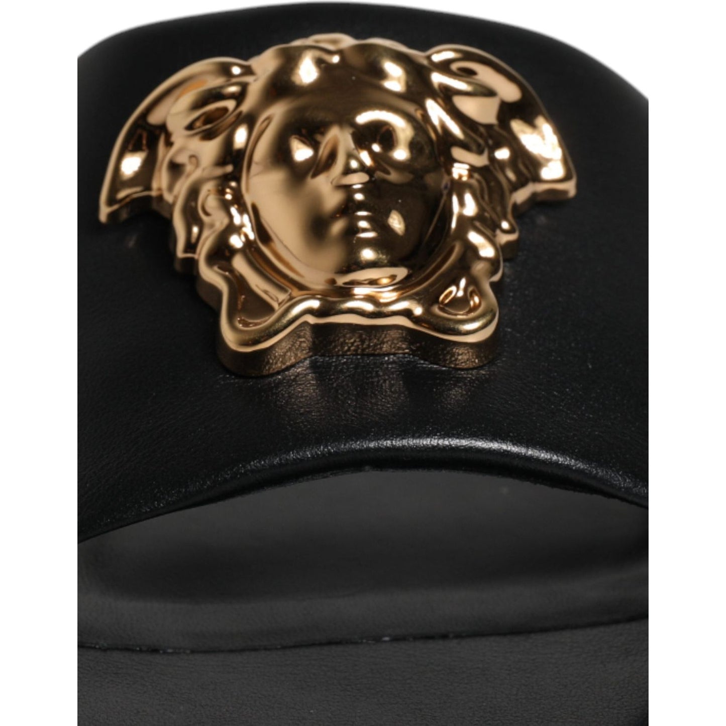 Versace black leather slides with gold logo plaque, open toe design, luxury Italian footwear.