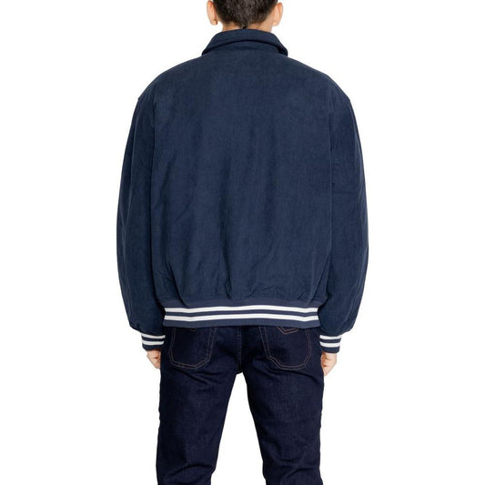 Back view of man wearing Tommy Hilfiger blue recycled polyester jacket, part of the men's fall/winter collection.