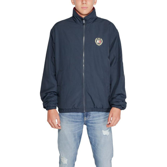 Tommy Hilfiger men's blue recycled polyester jacket, fall/winter collection, featuring a zip-up design and logo patch on the chest.