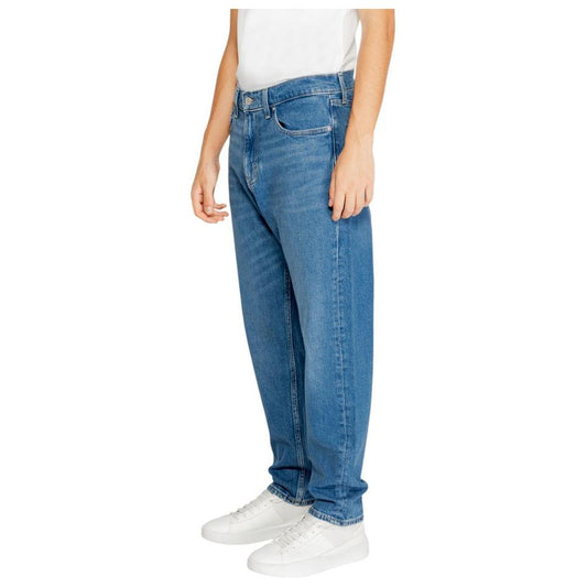 Men wearing Tommy Hilfiger blue jeans made from recycled cotton, part of the Fall/Winter collection, featuring a classic fit style.