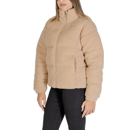 Woman wearing Columbia Beige Nylon Coat with Sherpa lining, showcasing front zip closure, perfect for winter city strolls and mountain hikes.