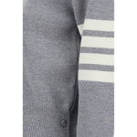 Close-up of Thom Browne Virgin wool Sweater showing iconic horizontal bands and ribbed hem with side buttons.