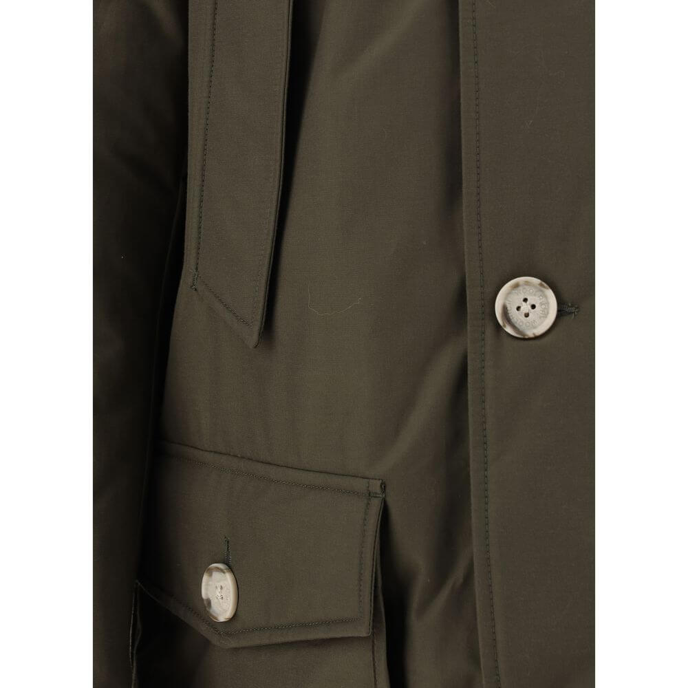 Close-up of Woolrich Green Cotton Parka featuring buttons and pocket detail. Made from 60% cotton and 40% polyamide.