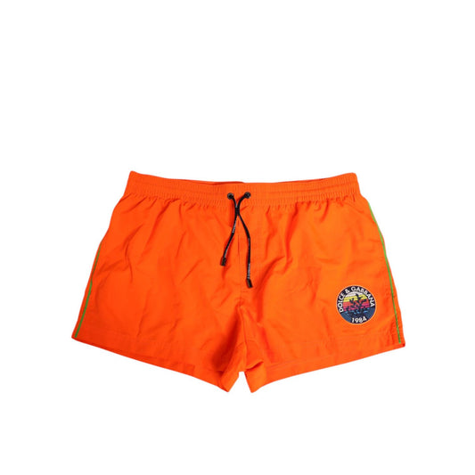 Dolce & Gabbana Orange Polyester Beachwear Men Shorts Swimwear with elastic waistband and logo details, front view.