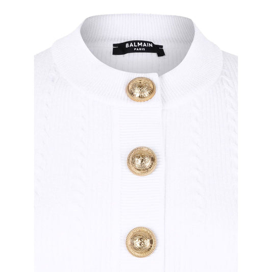 Close-up of the Balmain Ribbed buttoned top featuring white ribbed knit fabric and gold front button fastening.