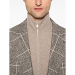 Man wearing Brunello Cucinelli Cashmere Zipped Cardigan with a brown high neck and zip fastening, styled under a plaid jacket.