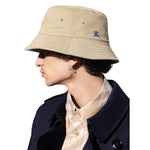 Man wearing Burberry Cotton Bucket Cap with Pegaso embroidery, flat crown, and low wide brim, featuring the Equestrian Knight motif.