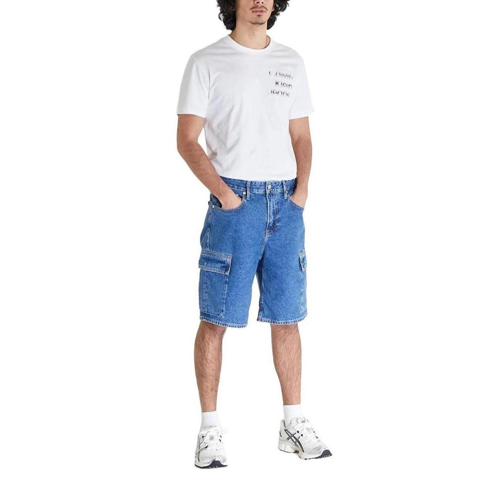 Male model wearing Calvin Klein Jeans Blue Cotton Bermuda shorts, part of spring/summer collection, made with 80% cotton, 20% recycled cotton.