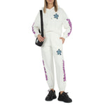 Alt Tag: Comme Des Fuckdown White Cotton Jeans & Pant with logo embroidery, side pockets, drawstring, worn by a person with a black bag.