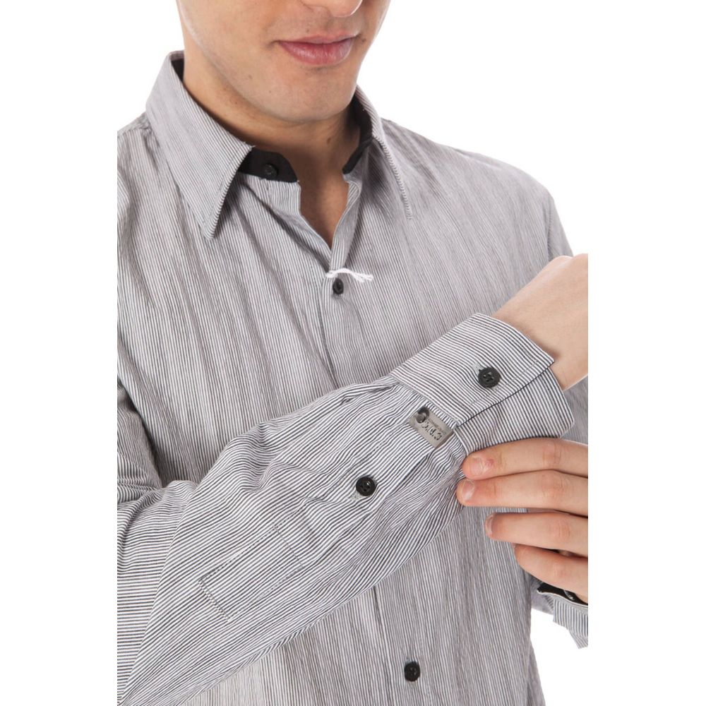 Man adjusting sleeve of a Costume National White Cotton Men Shirt, highlighting the button detailing and elegant Italian collar.