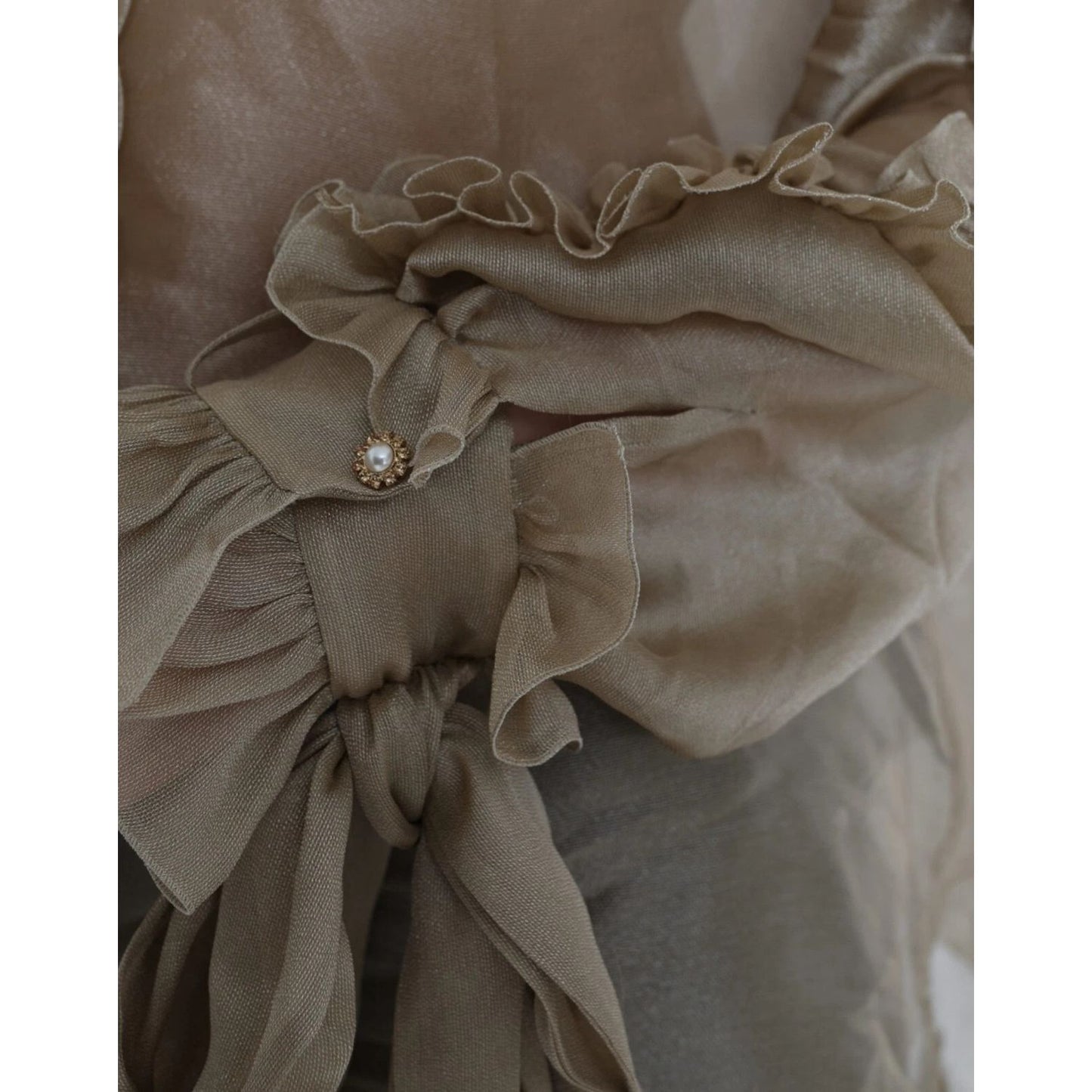 Close-up of Dolce & Gabbana Gold Ascot Collar Ruffles Blouse Top showcasing ruffles and button detail.