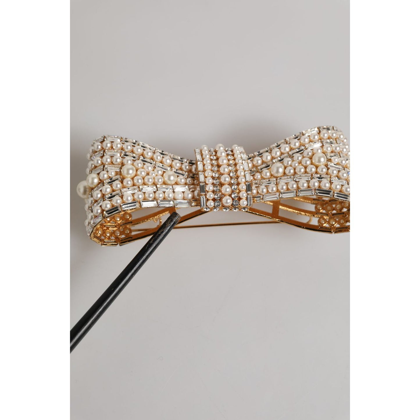 Dolce & Gabbana Gold Tone Brass Bow Crystal FauxPearl Embellished Brooch with replaced stones and logo details.