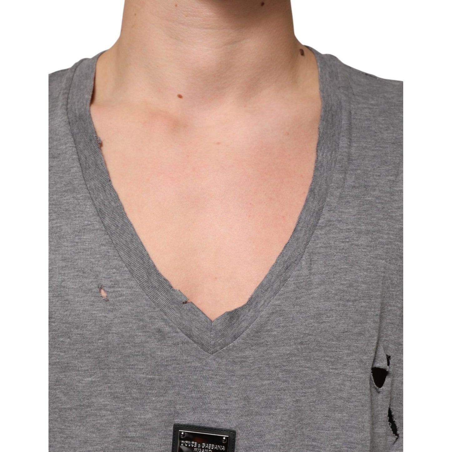 Close-up of Dolce & Gabbana Gray Cotton Tattered Logo Patch Men T-shirt with V-neck and distressed details.