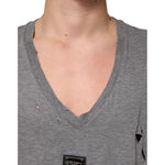 Close-up of Dolce & Gabbana Gray Cotton Tattered Logo Patch Men T-shirt with V-neck and distressed details.