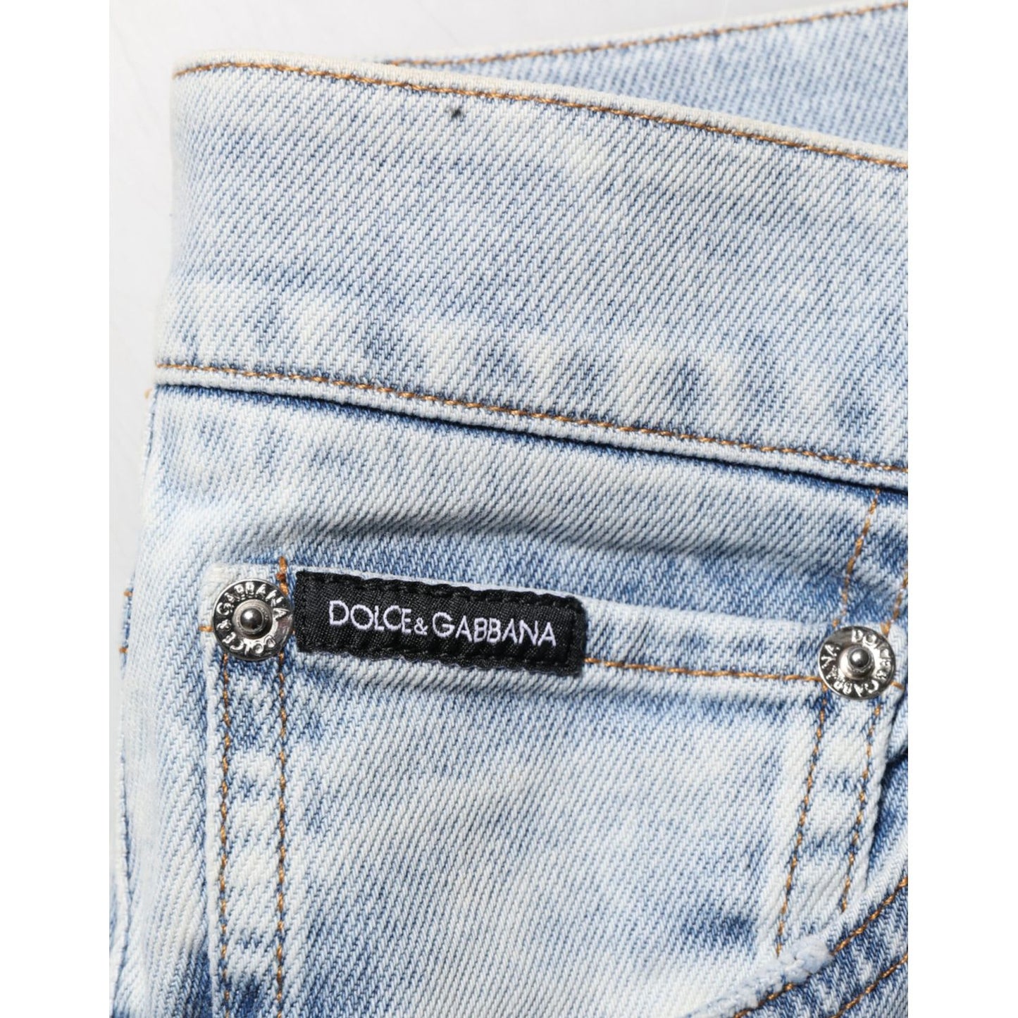 Close-up of Dolce & Gabbana Light Blue Distressed Slim Fit Ripped Denim Jeans back pocket with brand label.