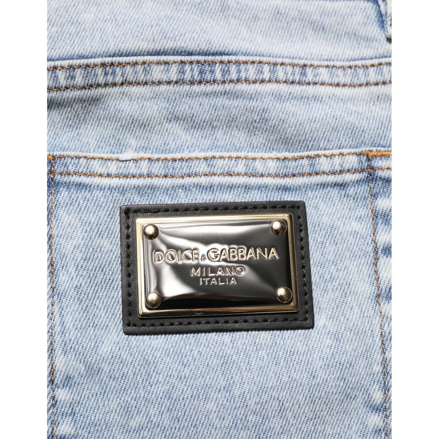 Close-up of Dolce & Gabbana Light Blue Distressed Slim Fit Ripped Denim Jeans showcasing emblem detail on pocket.