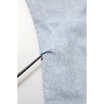 Detail of Dolce & Gabbana Light Blue Distressed Slim Fit Ripped Denim Jeans fabric showing distressed area with close-up view.