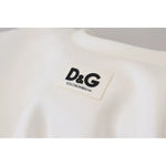Close-up of Dolce & Gabbana White Cotton Corset Stretch Top T-shirt logo detailing on front, featuring brand emblem in black on white fabric.