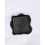 Dolce & Gabbana White Cotton Logo Patch V-neck Tee T-shirt featuring black logo emblem on soft cotton fabric.