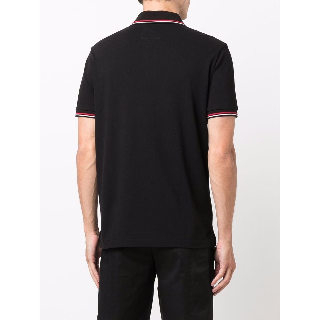 Back view of model wearing black Emporio Armani T-shirts and Polos with red and white accents, showcasing short sleeves and classic fit.