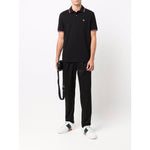 Model wearing Emporio Armani T-shirts and Polos Black with logo print, classic collar, short sleeves, and front button placket.