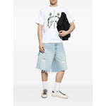 Model wearing Golden Goose Super-Star in nappa leather with leather star and leather heel tab sneakers, denim shorts, and white t-shirt.