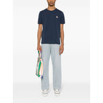 Maison Kitsuné Maison Kitsune Bold Fox Head cotton T-shirt in navy blue with Chillax Fox motif, modeled by person holding bag.