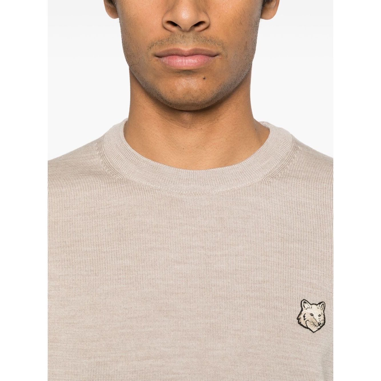 Model wearing Maison Kitsuné Maison Kitsune Fox motif sweater in light beige with crew neck and fox head logo, size M.