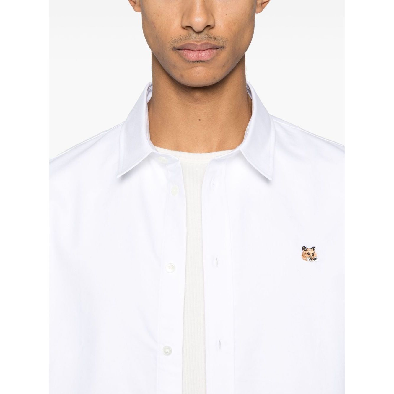 Maison Kitsuné Maison Kitsune classic shirt wth fox head logo, white cotton, buttoned-cuff sleeves, curved hem, worn by a model