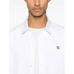Maison Kitsuné Maison Kitsune classic shirt wth fox head logo, white cotton, buttoned-cuff sleeves, curved hem, worn by a model