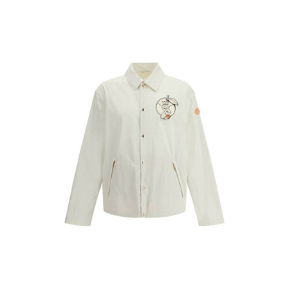 Moncler x Donald Glover White Cotton Coat with comic-style patches and Moncler mascot embroidery, part of Moncler Genius line.
