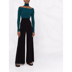 Norma Kamali Trousers Black, high-waisted flared Elephant jersey pants with pockets, regular length, modeled with green top.