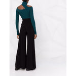 Back view of woman wearing Norma Kamali Trousers Black, high-waisted flared Elephant jersey with side slit pockets, full length.