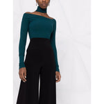 Norma Kamali Trousers Black high-waisted flared jersey trousers with side slit pockets, worn with a green off-shoulder top.