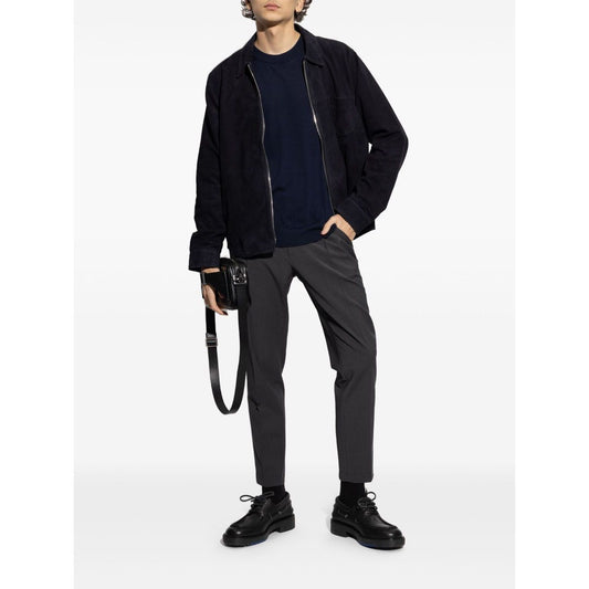 Model wearing Paul Smith Sweaters Blue, showcasing a navy blue crew neck sweater with long sleeves and ribbed trim, paired with casual trousers.