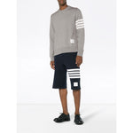 Model wearing Thom Browne Sweaters Light Grey with 4-Bar stripes and name tag appliqué, straight hem, crafted in Japan.